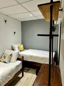 Zimmer mit 2 Betten und einem Kreuz an der Wand in der Unterkunft Swing & Pillows @ Beach Street in George Town