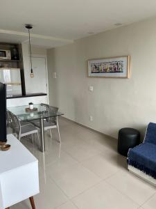 ein Wohnzimmer mit einem Tisch und einem blauen Stuhl in der Unterkunft Apto 301 in Caruaru