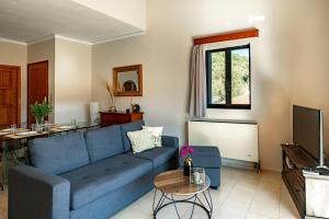 uma sala de estar com um sofá azul e uma mesa em Golden Flower's Apartment em Poros
