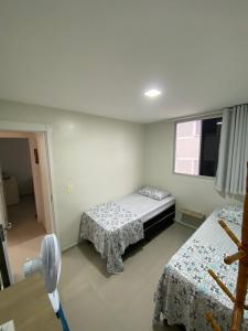 a bedroom with two beds and a fan at Apto 301 in Caruaru
