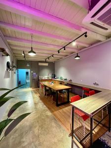 a room with tables and chairs and purple lights at Swing & Pillows @ Beach Street in George Town +35 photos