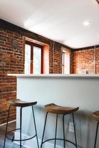 a bar with three stools in front of a brick wall at Three Trails in Elkin