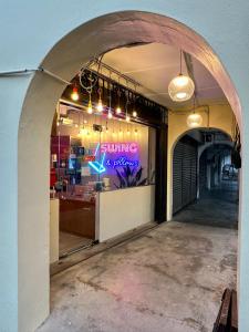 an entrance to a restaurant with a sign in the window at Swing & Pillows @ Beach Street in George Town