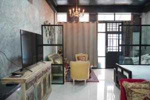 a living room with a tv and a chair at Vathanagul Resort in Chiang Rai