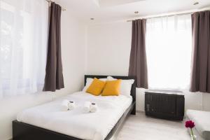 two white shoes sitting on a bed in a bedroom at Stílusos lakás ingyenes parkolással in Debrecen