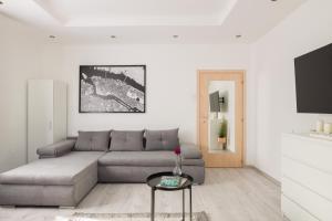 a living room with a couch and a table at Stílusos lakás ingyenes parkolással in Debrecen