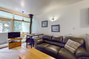 sala de estar con sofá de cuero y mesa en Sierra Del Sol 5 en Taos Ski Valley