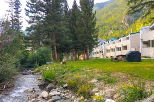 un arroyo frente a un edificio con una montaña en Sierra Del Sol 5, en Taos Ski Valley