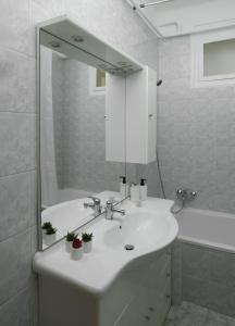 a white bathroom with a sink and a mirror at Stílusos lakás ingyenes parkolással in Debrecen