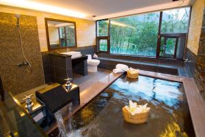 un bagno con un laghetto koi al centro di 礁溪景觀溫泉會館 a Jiaoxi