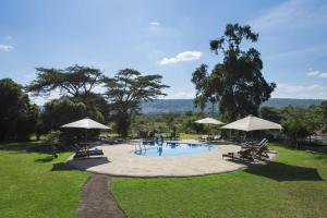 una piscina con sillas y sombrillas en un parque en Neptune Mara Rianta Luxury Camp - All Inclusive. en Masai Mara