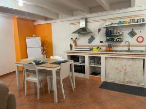een keuken met een tafel en stoelen en een wastafel bij Luxury Suite in Mesagne