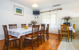 uma sala de jantar com mesa e cadeiras em Amazing Apartment In Dugi Rat With Kitchen em Dugi Rat