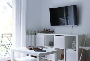 a living room with a white table and a tv on the wall at 3L in Samobor