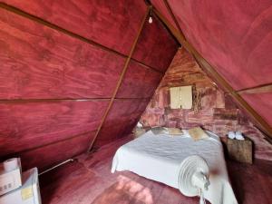 1 dormitorio con 1 cama en una habitación de color rojo en Eco Hotel Tahawi, en Ajijic