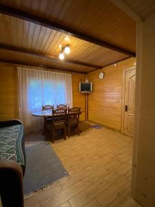 a living room with a table and chairs and a tv at Sadyba na Luzi in Verkhne-Studeny