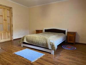 Verkhne-StudënyyにあるSadyba na Luziのベッドルーム1室(ベッド1台、テーブル2台、ドア付)
