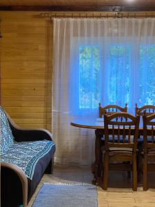 d'une salle à manger avec une table, des chaises et une fenêtre. dans l'établissement Sadyba na Luzi, à Verkhne-Studënyy