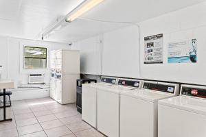 uma grande cozinha branca com electrodomésticos brancos em Developer Inn Maingate, a Baymont by Wyndham em Kissimmee