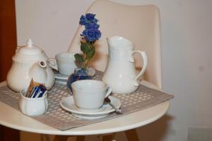 - une table avec des tasses de thé et des vases dans l'établissement IL GLICINE, à Sorrente