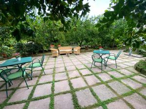 um pátio com duas mesas, cadeiras e árvores em IL GLICINE em Sorrento
