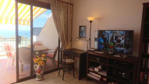 sala de estar con TV y mesa de comedor en Apartment mit Sonnenterrasse und Panorama - Meerblick, 5 Min. von Hafen + Strand en Acantilado de los Gigantes
