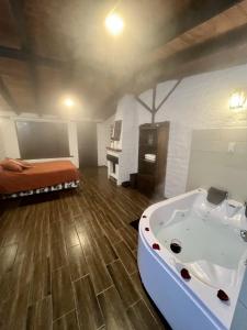 a room with a bath tub and a bed in it at Estancia De La Campiña in Nono