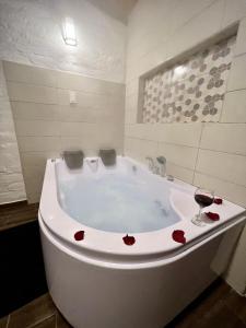a white bath tub with hearts on it with a glass of wine at Estancia De La Campiña in Nono