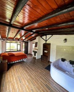 a bedroom with a bed and a bath tub in it at Estancia De La Campiña in Nono