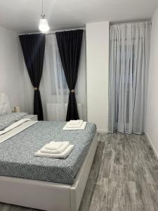 - une chambre avec un lit et 2 serviettes dans l'établissement Alice Residence, à Sibiu