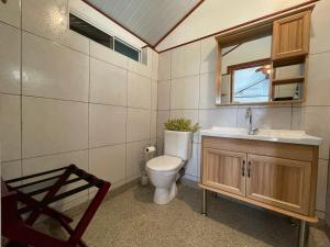 bagno con servizi igienici, lavandino e specchio di Huahine Beach House a Fare (Huahine Nui)