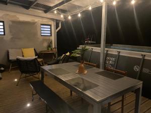 a dining room with a table and chairs and lights at Ti kaz bo - Chambre Combava chez l'habitant in Bras-Panon