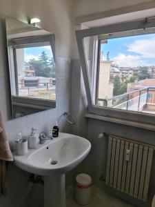 een badkamer met een wastafel en 2 ramen bij Casa Aurelia in Rome +3 foto's