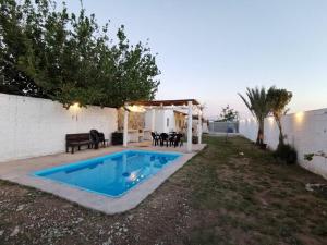 a swimming pool in a yard next to a house at Casa Ferriño in Cuatrociénegas de Carranza