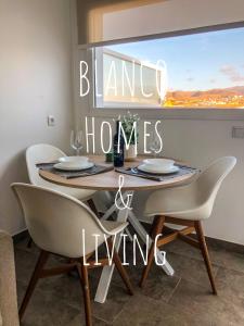 stół jadalny z krzesłami i tabliczka z pustymi domami w obiekcie Blanco Homes & Living 3A w mieście El Tablero