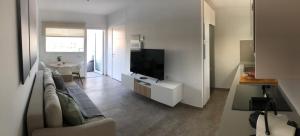 ein Wohnzimmer mit einem Sofa und einem Flachbild-TV in der Unterkunft Blanco Homes & Living 3A in El Tablero