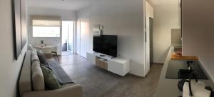un soggiorno con divano e TV a schermo piatto di Blanco Homes & Living 3A a El Tablero