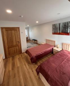 a bedroom with two beds and a wooden floor at Neris apartments in Šiauliai