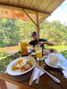 um homem sentado à mesa com um prato de comida em Playa Selva Lodge em Archidona
