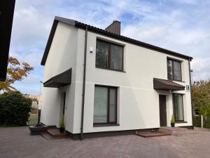 希奥利艾Neris apartments的街上的白色房屋,设有黑窗