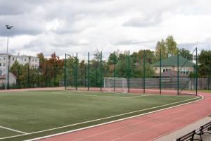 a tennis court with a net on a court at Neris apartments in Šiauliai