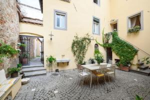 un patio con mesa y sillas en un edificio en Corte Paolina - charming courtyard inside Lucca, en Lucca