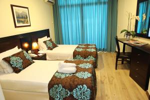 una camera d'albergo con due letti e una scrivania di Mozart Hotel a Beirut