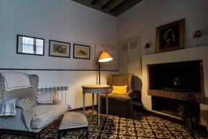 a living room with a couch and a chair and a fireplace at Hotel Rural La Vida de Antes in Consuegra