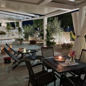 een patio met tafels en stoelen en een kaars bij Apartman Magnolija Umag in Umag