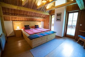 een slaapkamer met een groot bed in een kamer met houten wanden bij Chalet Zlatorog in Bohinj