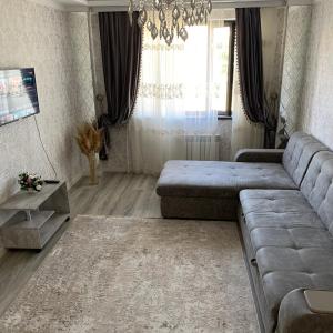 uma sala de estar com um sofá e um lustre em Apartment Vefa Bishkek em Bishkek