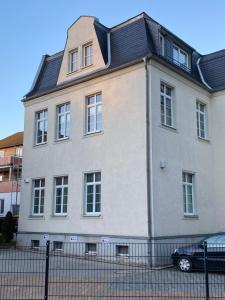 une grande maison blanche avec un toit noir dans l'établissement Bezauberndes Stadtidyll, à Lichtenstein