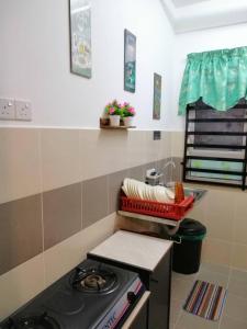 a small kitchen with a stove and a sink at Seroja Residence Kuala Terengganu in Kuala Terengganu