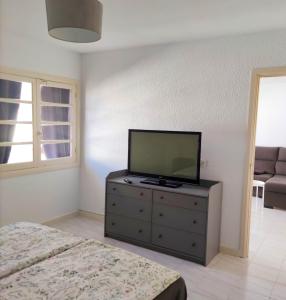 91 Port Royale Los Cristianos في لوس كريستيانوس: غرفة نوم مع تلفزيون بشاشة مسطحة على خزانة ملابس